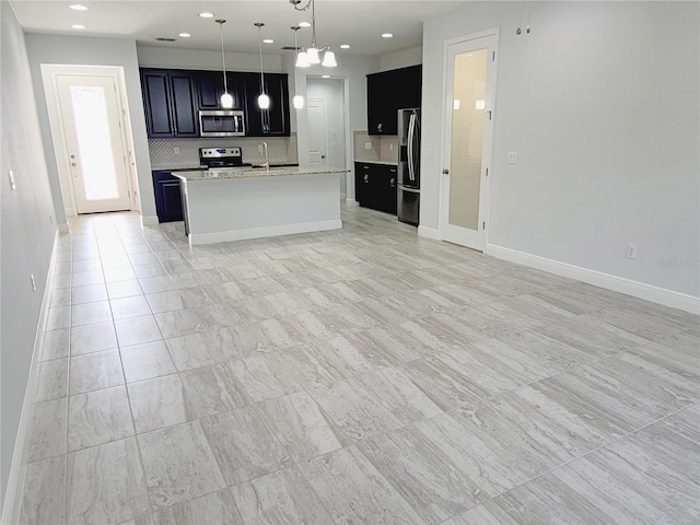 5509 Cumberland Star Ct, Lutz, FL 33558 - kitchen featuring appliances with stainless steel finishes, open floor plan, dark cabinets, a sink, and recessed lighting