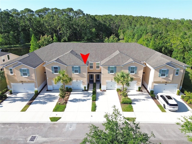 5509 Cumberland Star Ct, Lutz, FL 33558 - view of front of house with a garage, driveway, stucco siding, and a wooded view