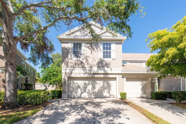 view of front facade featuring driveway, stucco siding, and an attached garage