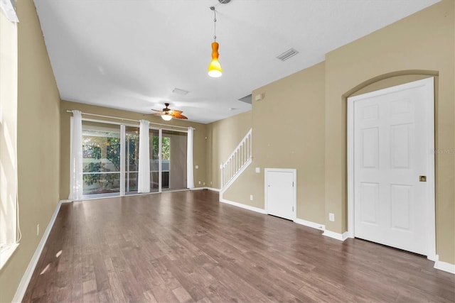 unfurnished living room with wood finished floors, a ceiling fan, and baseboards