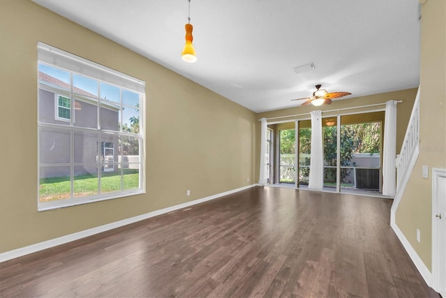 unfurnished living room with wood finished floors, plenty of natural light, and a ceiling fan