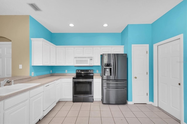 kitchen featuring a sink, stainless steel appliances, visible vents, light countertops, and white cabinets