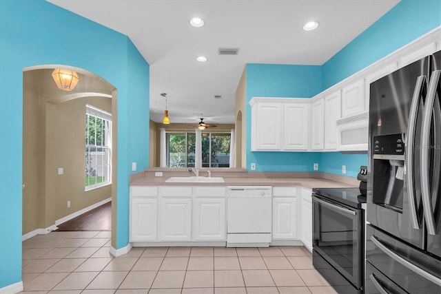 kitchen with arched walkways, stainless steel appliances, light countertops, a sink, and visible vents