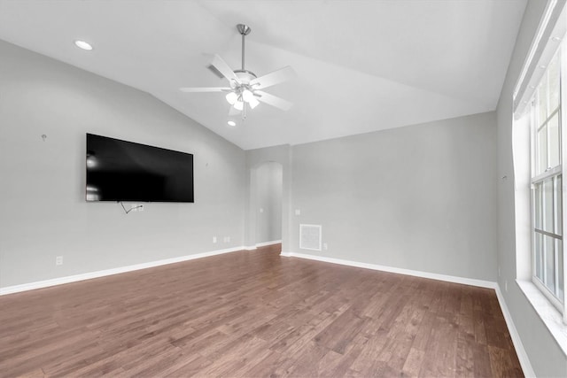 unfurnished living room with wood finished floors, a wealth of natural light, vaulted ceiling, ceiling fan, and visible vents