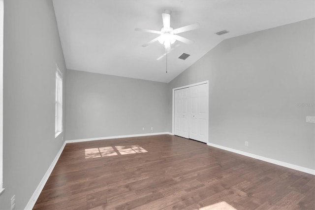unfurnished bedroom featuring visible vents, wood finished floors, and vaulted ceiling