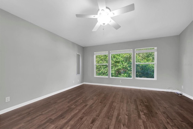 empty room featuring ceiling fan, dark wood-style floors, and baseboards