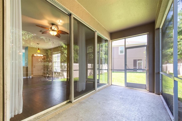 unfurnished sunroom featuring a ceiling fan