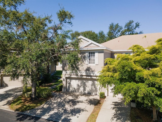 view of front facade featuring driveway, stucco siding, and a garage