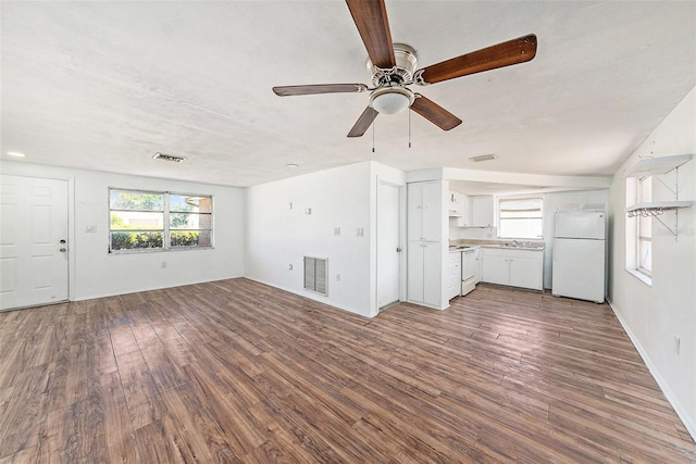 1051 Normandy Blvd, Holiday, FL 34691 - unfurnished living room with baseboards, a ceiling fan, visible vents, and dark wood finished floors