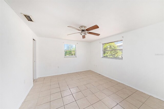 1051 Normandy Blvd, Holiday, FL 34691 - spare room featuring light tile patterned flooring, visible vents, a ceiling fan, and baseboards