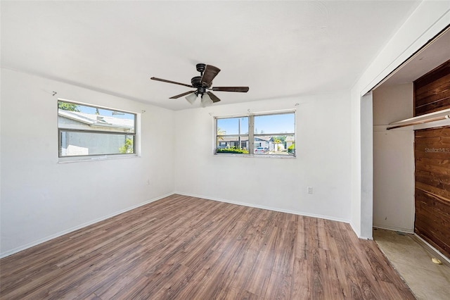 1051 Normandy Blvd, Holiday, FL 34691 - unfurnished bedroom with wood finished floors, a closet, baseboards, and multiple windows