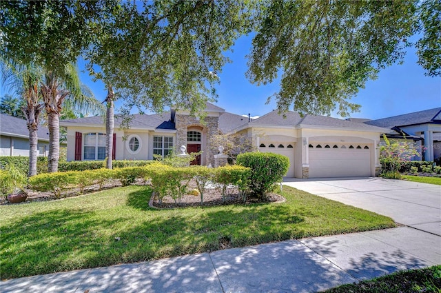 single story home with driveway, stone siding, an attached garage, a front yard, and stucco siding