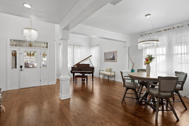 3325 W Wallcraft Ave, Tampa, FL 33611 - dining space featuring visible vents, wood-type flooring, crown molding, decorative columns, and a notable chandelier