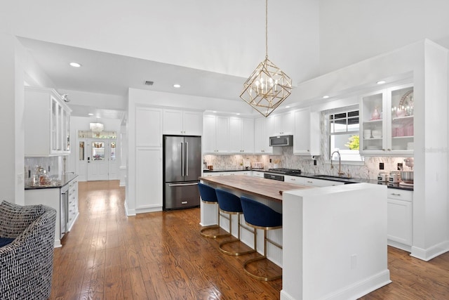 3325 W Wallcraft Ave, Tampa, FL 33611 - kitchen featuring a center island, a sink, butcher block counters, white cabinetry, and appliances with stainless steel finishes