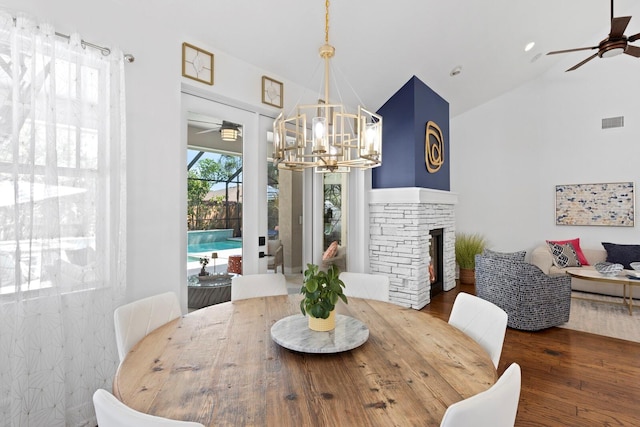 3325 W Wallcraft Ave, Tampa, FL 33611 - dining room featuring visible vents, high vaulted ceiling, ceiling fan with notable chandelier, wood finished floors, and a fireplace