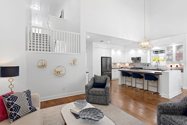 3325 W Wallcraft Ave, Tampa, FL 33611 - living area featuring a towering ceiling, baseboards, wood finished floors, and a notable chandelier