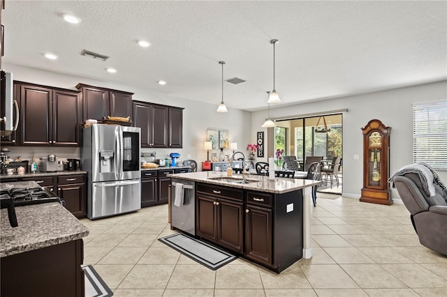 21383 Southern Charm Dr, Land O Lakes, FL 34637 - kitchen with stainless steel appliances, a kitchen island with sink, a sink, and light tile patterned flooring
