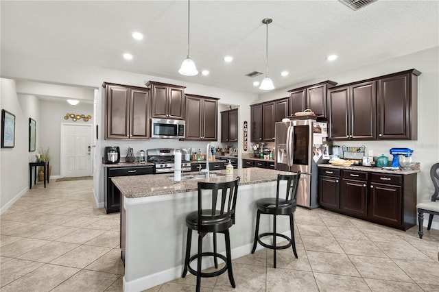 21383 Southern Charm Dr, Land O Lakes, FL 34637 - kitchen with dark brown cabinetry, light tile patterned floors, a sink, and stainless steel appliances