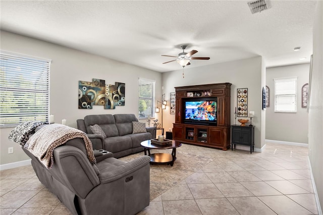 21383 Southern Charm Dr, Land O Lakes, FL 34637 - living room featuring plenty of natural light, ceiling fan, visible vents, and light tile patterned floors