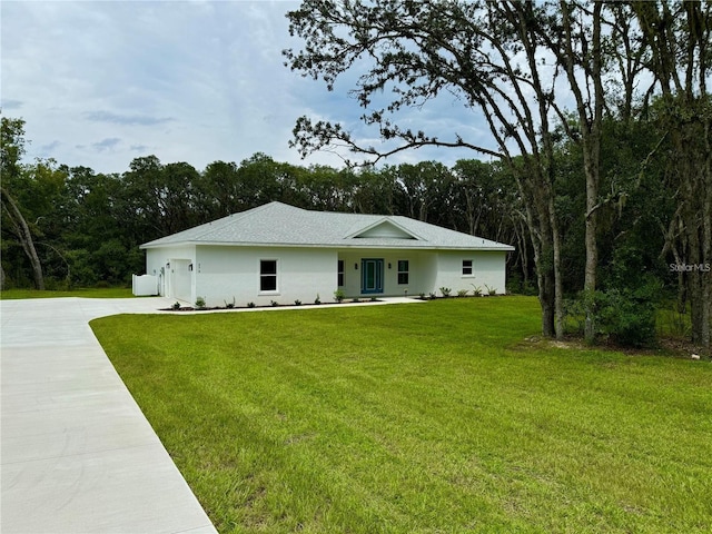 view of front of home featuring a front yard, roof with shingles, stucco siding, and concrete driveway