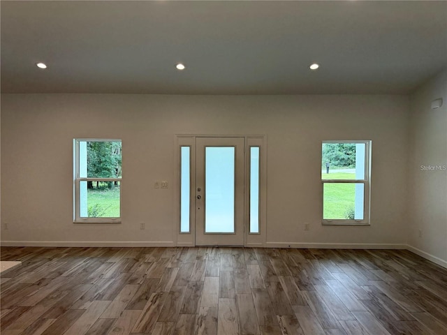 spare room featuring wood finished floors, baseboards, and recessed lighting