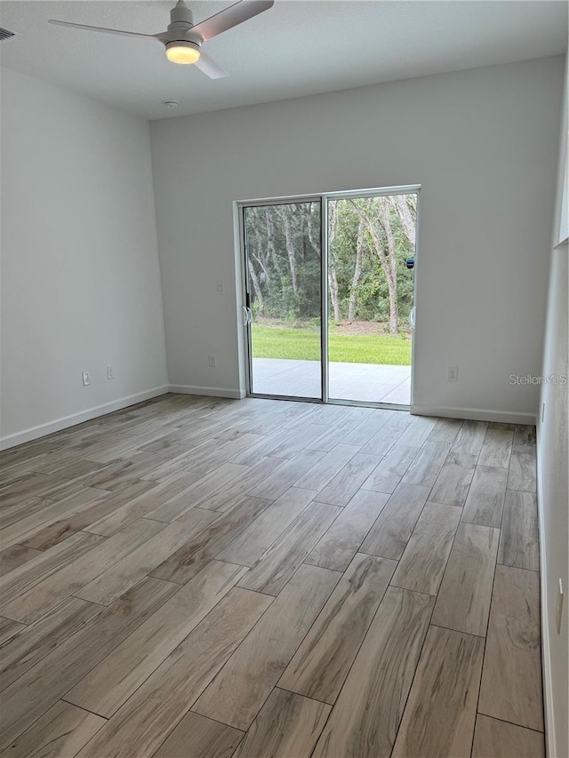 unfurnished room featuring light wood-style floors, baseboards, visible vents, and ceiling fan