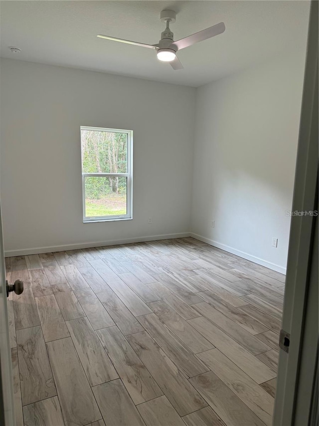 spare room with ceiling fan, wood finished floors, and baseboards