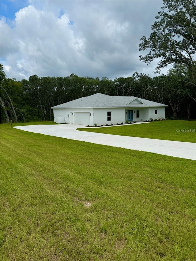 view of side of property featuring a yard, an attached garage, and concrete driveway