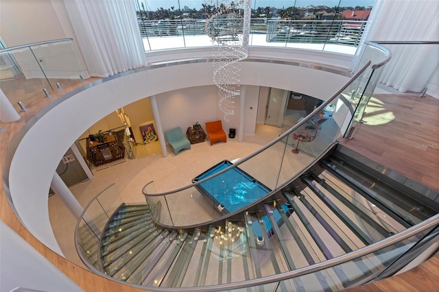 12650 7th St E, Treasure Island, FL 33706 - stairs with an inviting chandelier, a healthy amount of sunlight, and wood finished floors