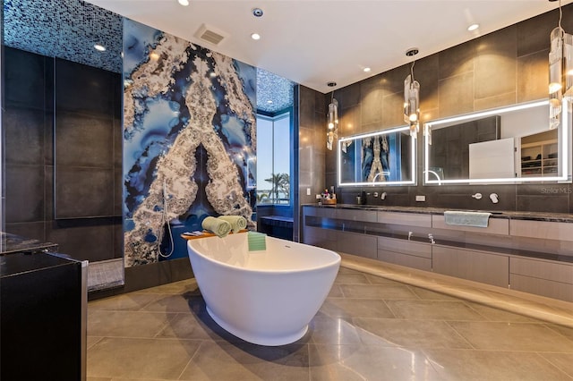 12650 7th St E, Treasure Island, FL 33706 - full bathroom with a sink, visible vents, recessed lighting, a soaking tub, and double vanity