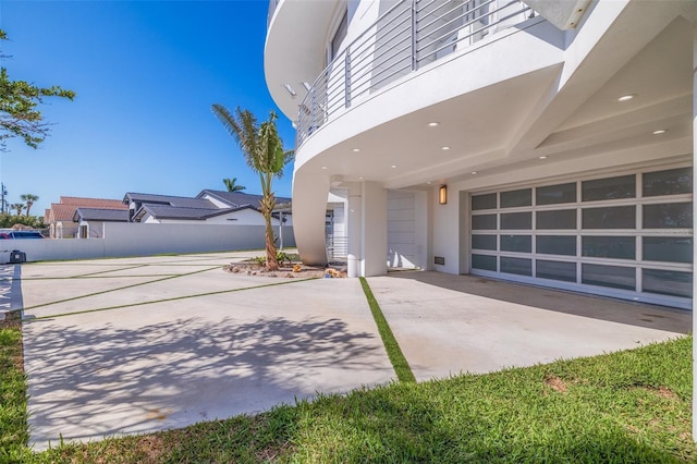 12650 7th St E, Treasure Island, FL 33706 - exterior space with concrete driveway, stucco siding, a garage, and fence