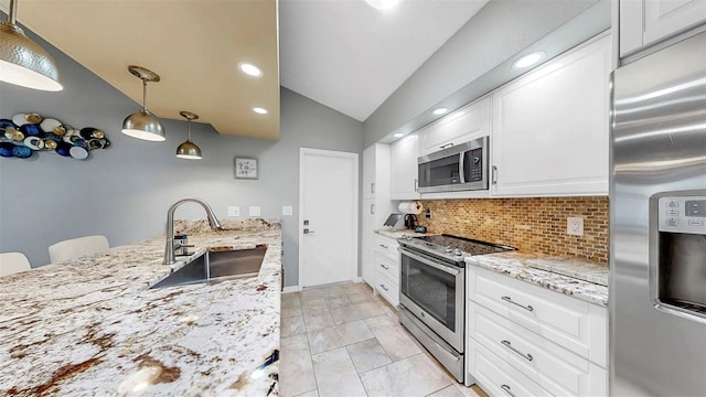 1613 E Del Webb Blvd, Sun City Center, FL 33573 - kitchen with appliances with stainless steel finishes, a sink, vaulted ceiling, decorative backsplash, and white cabinetry