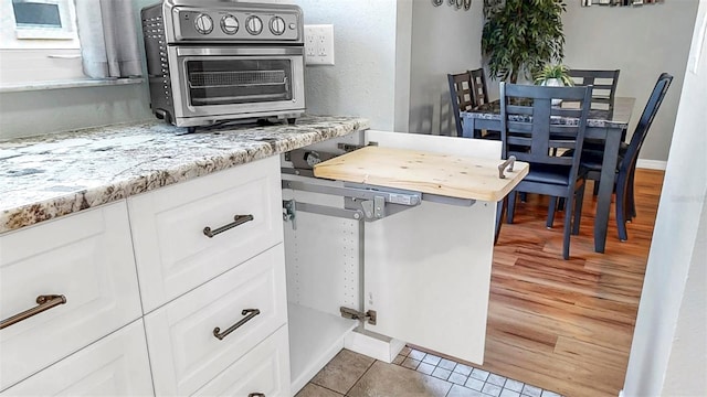 1613 E Del Webb Blvd, Sun City Center, FL 33573 - kitchen featuring white cabinetry and light tile patterned floors
