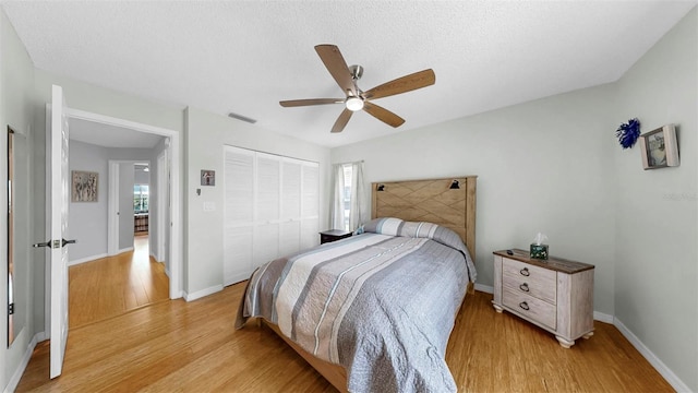 1613 E Del Webb Blvd, Sun City Center, FL 33573 - bedroom featuring light wood-style floors, a closet, a ceiling fan, baseboards, and a textured ceiling