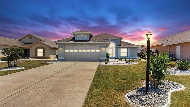 1613 E Del Webb Blvd, Sun City Center, FL 33573 - view of front of home featuring a front lawn, an attached garage, driveway, and stucco siding