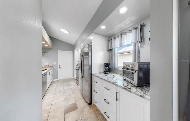 1613 E Del Webb Blvd, Sun City Center, FL 33573 - kitchen with stainless steel appliances, white cabinetry, light stone counters, recessed lighting, and lofted ceiling