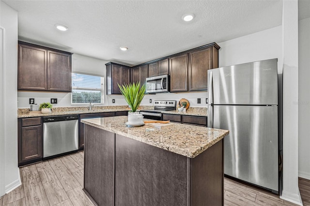 5429 Companion Ln, Tampa, FL 33619 - kitchen with dark brown cabinetry, light stone countertops, stainless steel appliances, and a sink