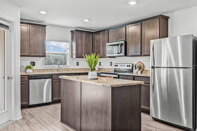 5429 Companion Ln, Tampa, FL 33619 - kitchen featuring appliances with stainless steel finishes, dark brown cabinets, and light wood finished floors