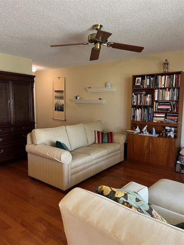 living area featuring a textured ceiling, wood finished floors, and a ceiling fan