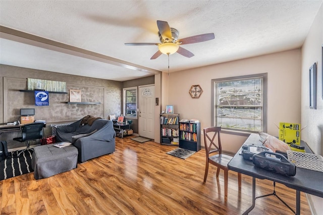 1025 W Berry Ave, Tampa, FL 33603 - living room with a textured ceiling, wood finished floors, a healthy amount of sunlight, and ceiling fan