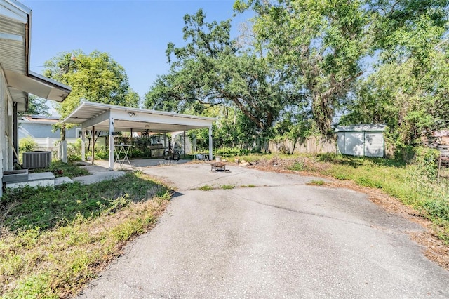 1025 W Berry Ave, Tampa, FL 33603 - exterior space with a storage shed, central AC, driveway, an outdoor structure, and a carport