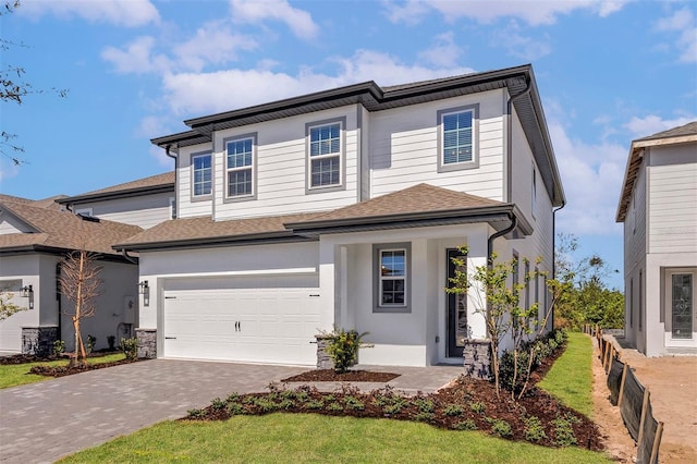 view of front of property with a garage, stucco siding, and decorative driveway