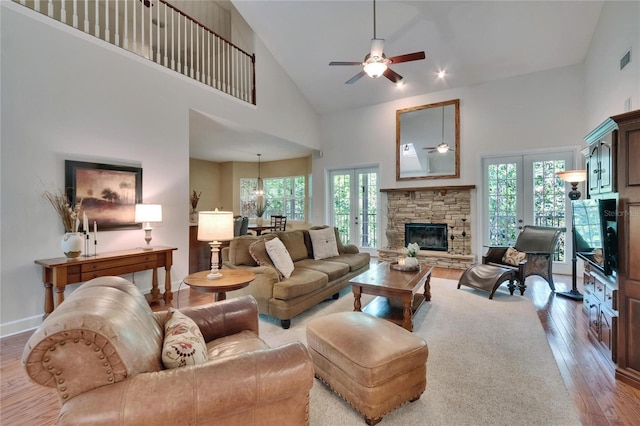 16420 Iola Woods Trl, Dade City, FL 33523 - living area featuring a fireplace, french doors, ceiling fan, high vaulted ceiling, and hardwood / wood-style flooring