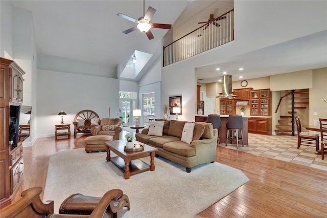 16420 Iola Woods Trl, Dade City, FL 33523 - living area featuring light wood-style flooring, high vaulted ceiling, a ceiling fan, and stairs