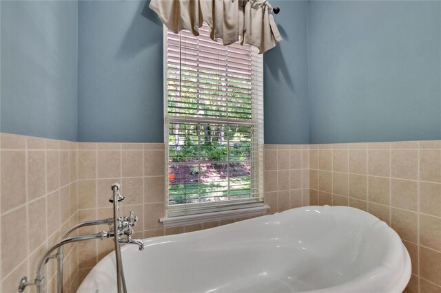 16420 Iola Woods Trl, Dade City, FL 33523 - bathroom with a tub, a wealth of natural light, and tile walls