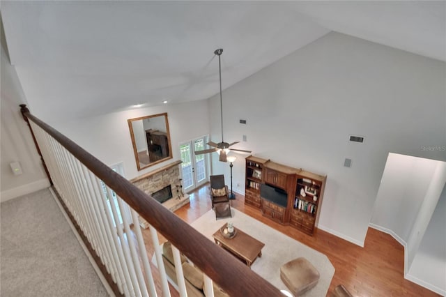 16420 Iola Woods Trl, Dade City, FL 33523 - living area featuring wood finished floors, high vaulted ceiling, a ceiling fan, and a stone fireplace