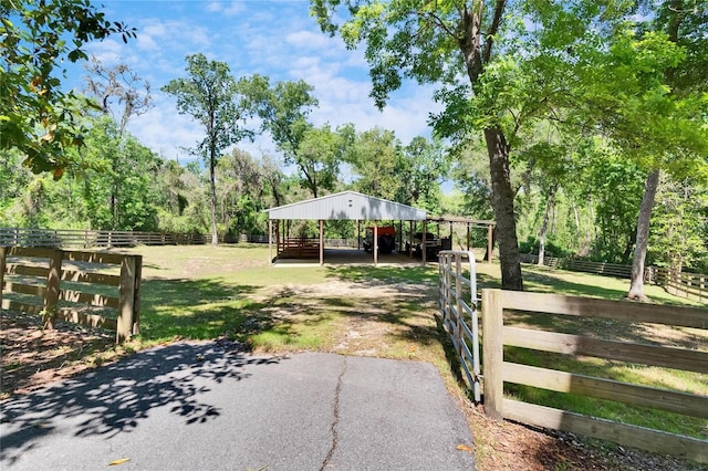 16420 Iola Woods Trl, Dade City, FL 33523 - view of yard featuring a carport, an outbuilding, aphalt driveway, and an exterior structure