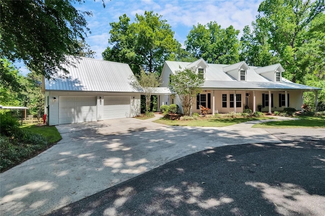 16420 Iola Woods Trl, Dade City, FL 33523 - cape cod home featuring a garage, metal roof, and driveway