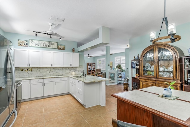 8116 Sanguinelli Rd, Land O Lakes, FL 34637 - kitchen with white cabinets, a peninsula, tasteful backsplash, visible vents, and ceiling fan