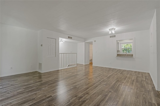 105 4th Ave NE Unit 220, Saint Petersburg, FL 33701 - unfurnished room featuring dark wood-type flooring, visible vents, and baseboards